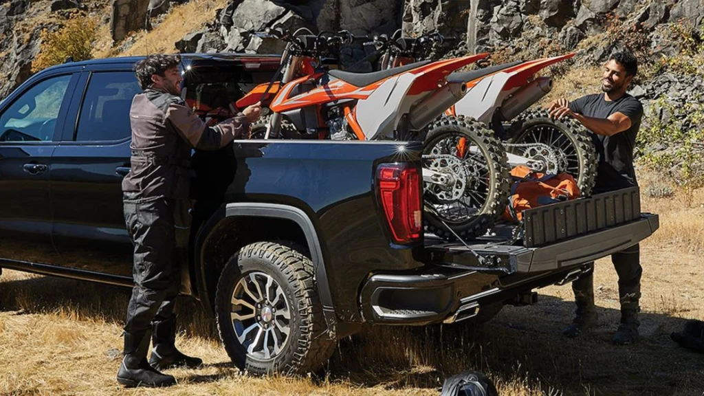GMC Sierra AT4 with 2 dirt bikes in the truck bed using the GMC MultiPro Tailgate as a load stop