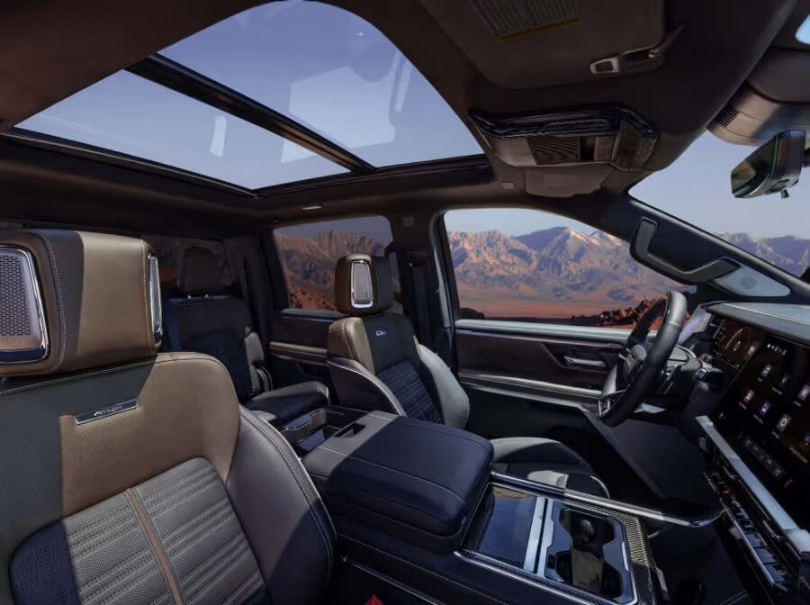 2027 GMC Sierra 1500 AT4X interior with panoramic sunroof and mountain views
